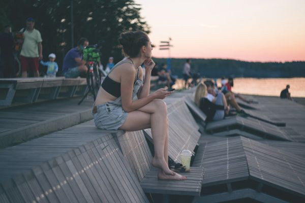 A girl sitting at the lake in the city