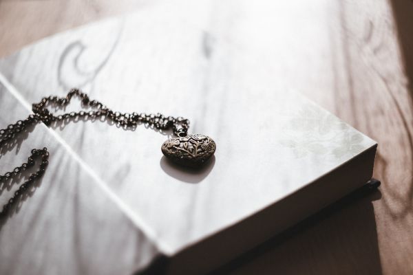 A heart necklace on an open book