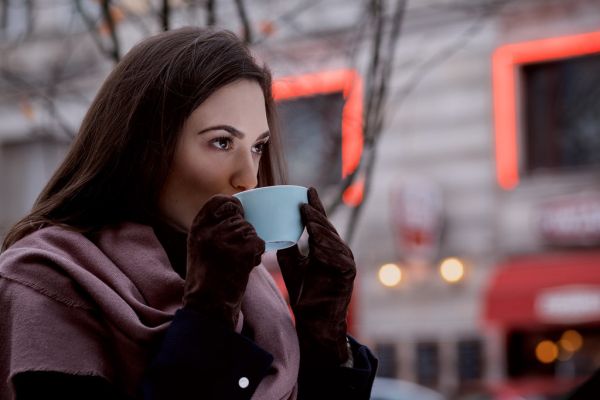 A woman drinking coffee outdoors