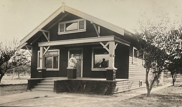 A young mother and her child on the front porch of their home