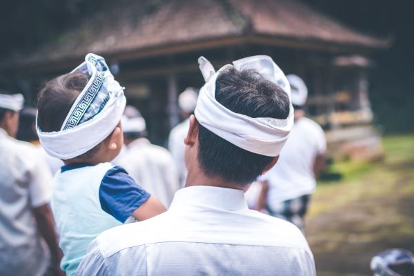 BALI, INDONESIA - JULY 4, 2018: Balinese children on a traditional ceremony. Baby with father.