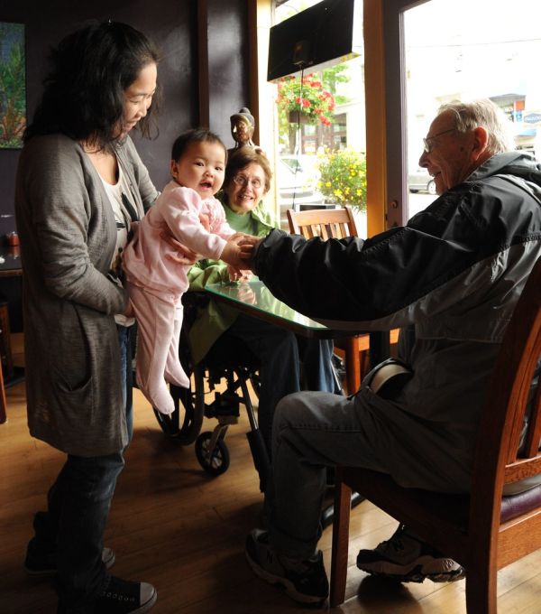 Blue Sky in pink, happy baby girl playing with new friends, holding hands, Buddha statue, red flowers, Uma Thai restaurant, Ballard, Seattle, Washington, USA