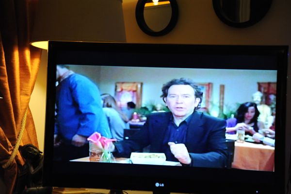 Buddhism in American Culture: Super Bowl ad, with Timothy Hutton, Tibetan Buddhist restaurant, Buddha statue, thangkas, flowers, TV, mirror, lamp, Buddha statue, gold curtains, Seattle, Washington, US...