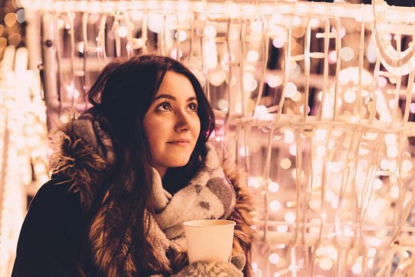 Christmas lights and girl holding coffee