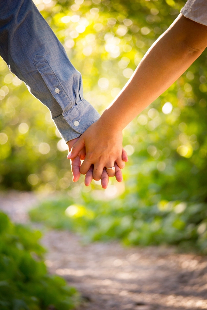 Close-up couple's interlaced hands trail