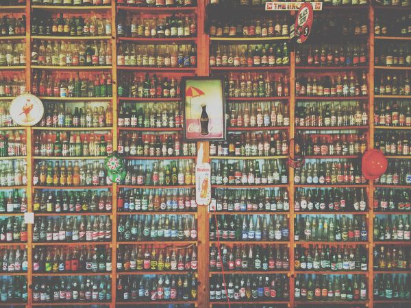 Collection of Glass Soda and Beer Bottles on Shelves