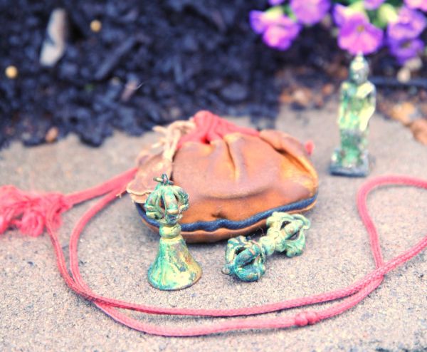 Contents from an old Tibetan Buddhist Trungwas, or protection amulets, dorje, bell, statue of Maitreya, the Buddha of the future seated, blessing cord, bag, Garden for the Buddha, Seattle, Washington,...
