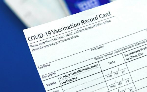 COVID-19 vaccination record card close up on table in hospital