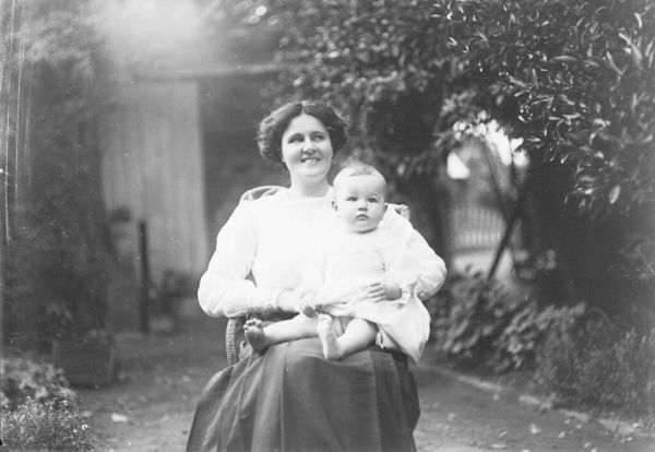 GN00430 Mother with baby on knee in garden