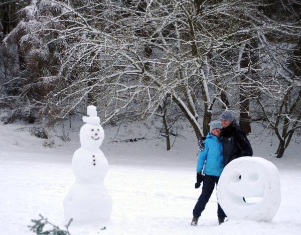 Hugs! Liz and Tyler with their sculptures, classic snowman, Happy Face, winter gear, hats, gloves, snow day, freedom, Greenlake, Seattle, Washington, USA