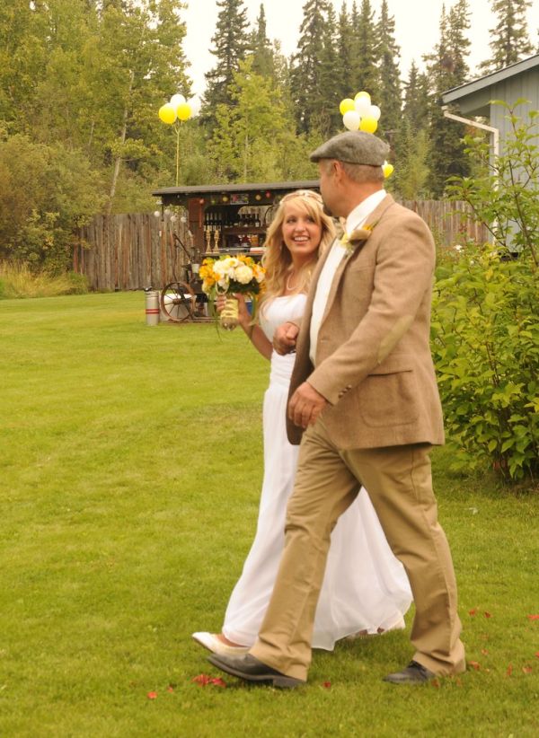 Jessie walks with her father towards a new life, holding her bouquet, white wedding dress, The Morse's, Fairbanks, Alaska, USA
