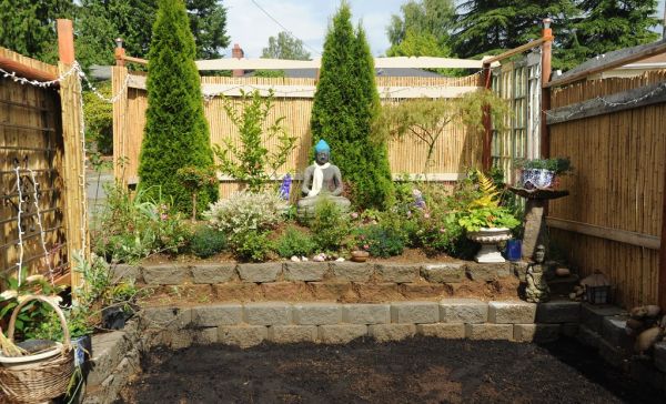 Last time I saw the Garden for the Buddha, Amitabha statue wearing a khata, trees, flowers, bushes, planters, bamboo fence, recycled wood, freshly planted grass seed, concrete block wall, Seattle, Was...