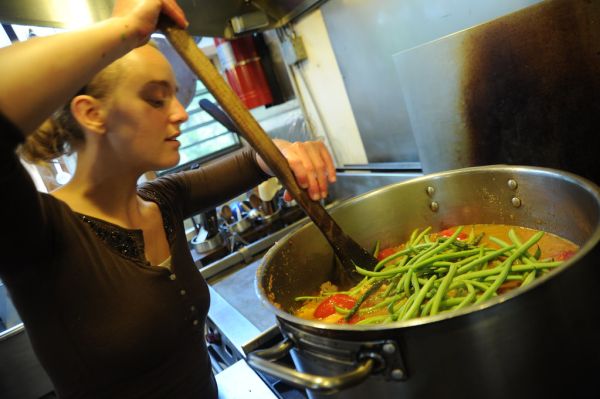 Making vegetarian green bean soup, cook, young woman in a brown shirt, pot, kitchen, Breitenbush Hot Springs, Breitenbush, Oregon, USA