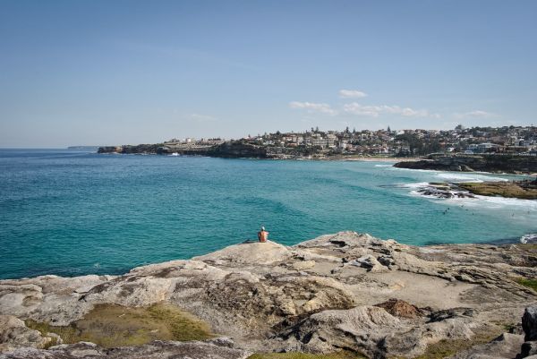 Man Sitting on Seacoast Rock