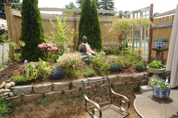 Plants are planted in A Garden for the Buddha, patio table, chairs, bamboo fence, Seattle, Washington, USA