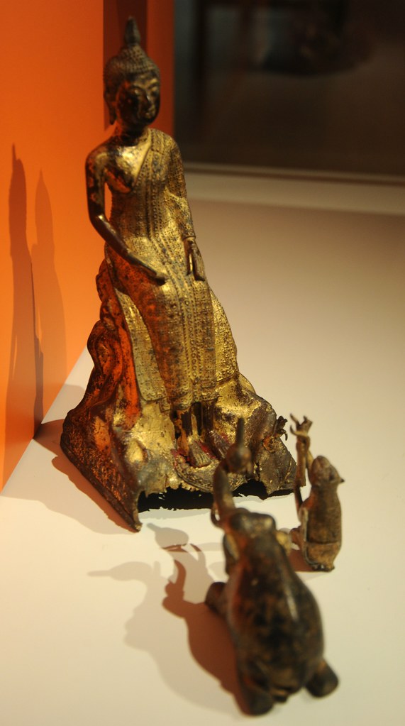 The Buddha spends a rainy season retreat at the palilaya forest, with an elephant and a monkey as attendants, gilt covered metal, statue of Lord Buddha, elephant holding fruit, monkey holding honey co...