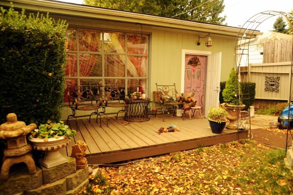 The new front deck in the winter, patio furniture, Rosie's dog toys, Japanese lantern, plants, wood, front door, window covered with plastic for insulation, arch, A Garden for the Buddha, Seattle, Was...