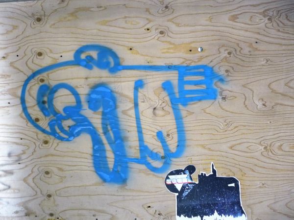 Urban street-art graffiti on a wooden construction-wall on Plantage Muidergracht: a painted blue sign and a pasted black-white image; photo Amsterdam city; urban photographer Fons Heijnsbroek, 2013