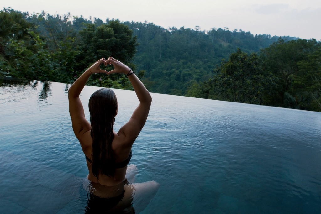 woman meditating infinity pool overlooking