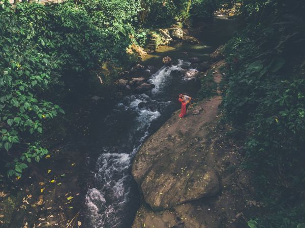 Young and happy couple kissing on the mountain river in the jungle of Bali island.
